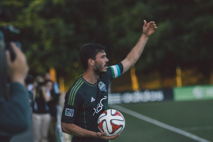Seattle Sounders player prepares for a throw-in during an MLS match, reflecting the league’s player bonus system.