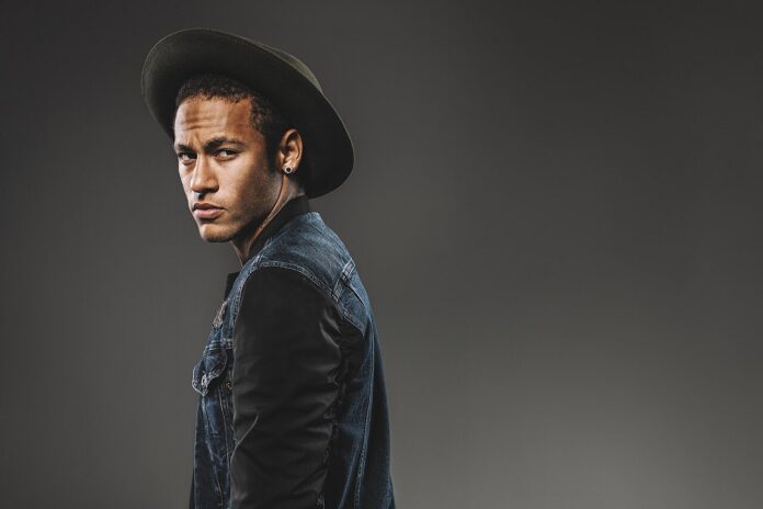 Neymar Jr., one of football’s most followed players, posing in a hat and denim jacket.