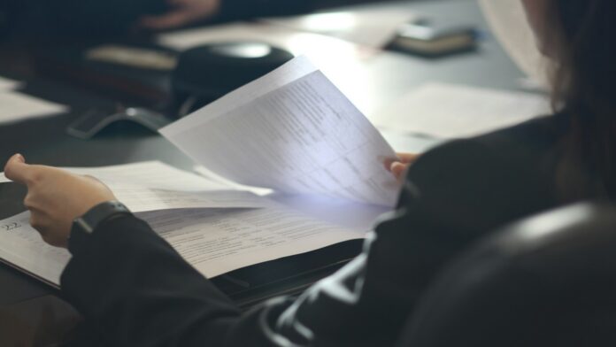A football professional reviewing documents representing an MLS player contract and Marketing Addendum.