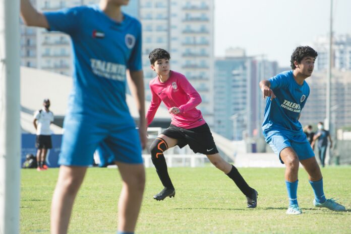 Football players competing on the pitch, illustrating pressure, awareness and coherent performance in football.