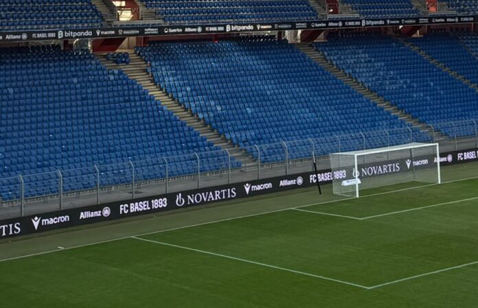 ponsor logos displayed at St. Jakob-Park, highlighting football’s commercial appeal to global brands.