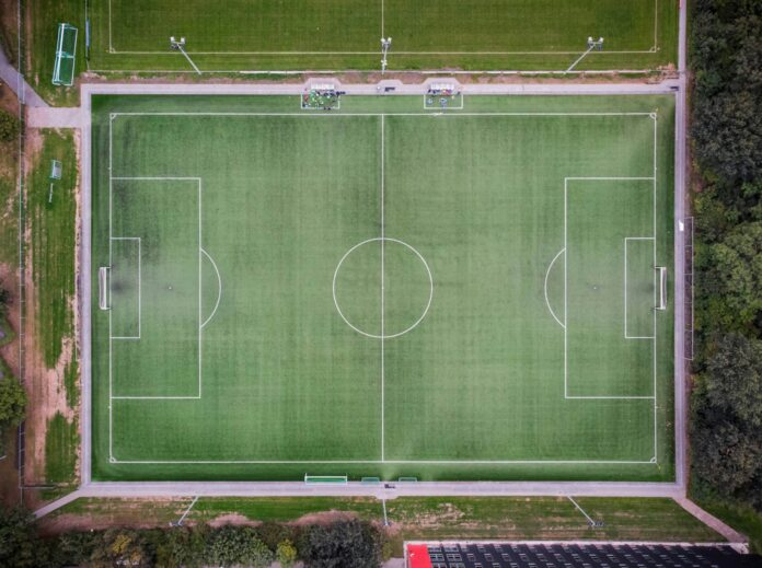 Aerial view of a football training ground with a full-size pitch, goals and additional training fields.